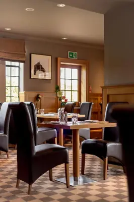 a waiting room with a table and chairs at Western House Hotel At Ayr Racecourse in Ayr