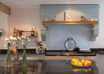 a kitchen with a counter with a bowl of fruit on a table at Bishopcleugh Guest House in Lockerbie