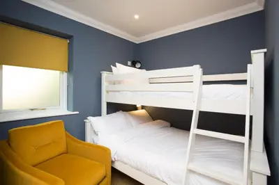 a bedroom with two bunk beds and a chair at Willowbeck Lodge Boutique Hotel in Carlisle