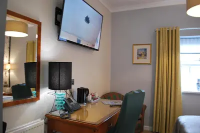 a room with a desk and a television on the wall at The Lion and The Lamb in Seascale