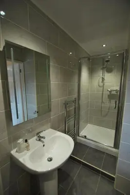 a bathroom with a sink and a shower at The Lion and The Lamb in Seascale