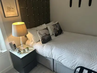 a bed with two pillows and a lamp on a night stand at Beechwood Ensuite Guest House in Ayr