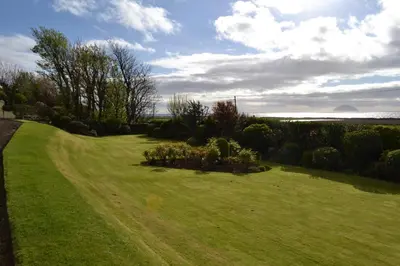 a field of grass with a dirt road at Burnside Farm B & B in Girvan