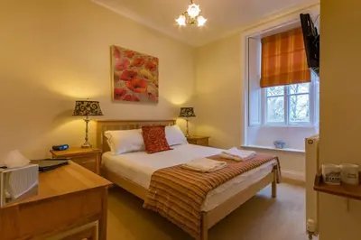 a bedroom with a bed and a window at Powe House in Keswick