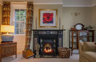 a living room with a fireplace with a fire in it at Powe House in Keswick