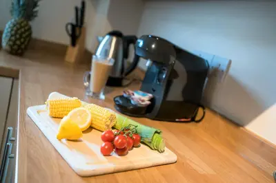 a cutting board with corn and vegetables on a counter at Wordsworth Apartment Irene court in Cockermouth