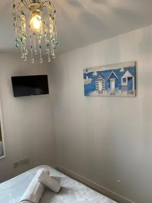 a bedroom with a bed and a chandelier at Mossie Apartment in Ayr