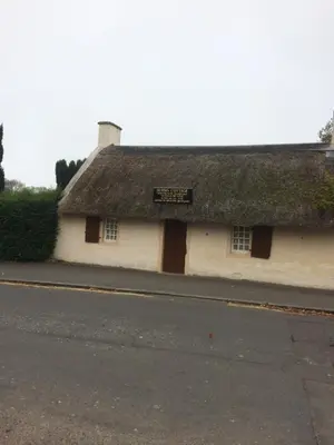 a building with a thatched roof on a street at Mossie Apartment in Ayr