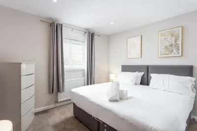 a bedroom with a large white bed and a window at Harbour House - Donnini Apartments in Ayr