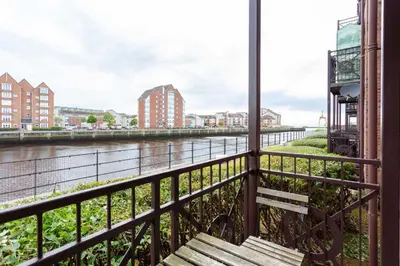 a balcony with a view of a river at Harbour House - Donnini Apartments in Ayr