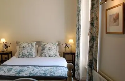 a bedroom with a bed with blue and white pillows at Warwick Hall in Carlisle