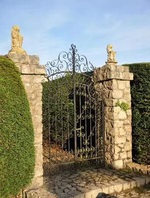 a gate to a garden with a hedge at Carnell Country Estate & Holiday Cottages in Ayrshire in Hurlford