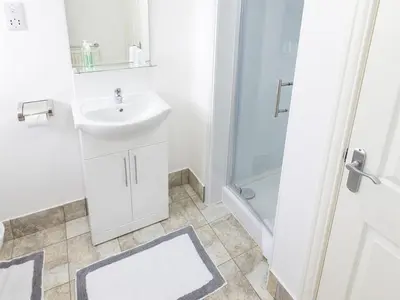 a white bathroom with a sink and a shower at The Golf Hotel in Silloth