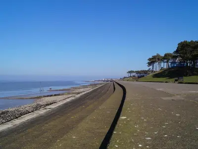 an empty road next to the ocean on a beach at The Golf Hotel in Silloth