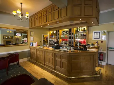 a bar in a pub with a man at the counter at The Golf Hotel in Silloth