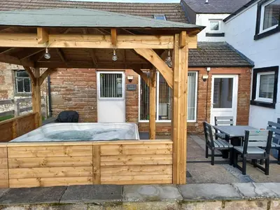a wooden pavilion with a hot tub in a patio at Green View Lodges in Wigton