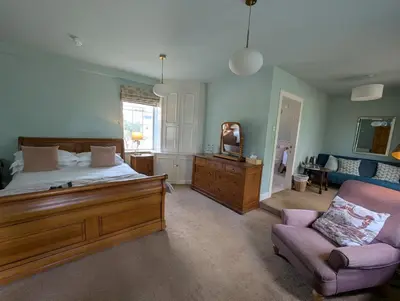 a bedroom with a bed and a couch and a chair at Trigony Hotel and Garden Spa in Closeburn