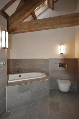 a bathroom with a bath tub and a toilet at The Barn at Ballaloaghtan in Ballasalla