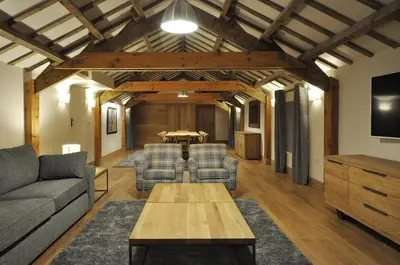 a living room with a couch and a table at The Barn at Ballaloaghtan in Ballasalla