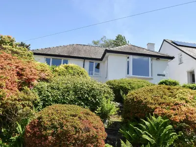 a white house with bushes in front of it at Brandelhow in Keswick