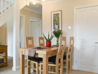 a dining room table with chairs and a vase of flowers at Brandelhow in Keswick