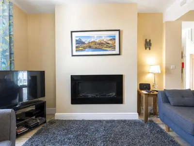 a living room with a fireplace and a tv at Tommy's Cottage in Keswick