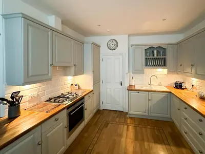 a kitchen with white cabinets and a clock on the wall at Breckenridge in Keswick