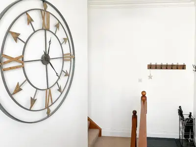a clock hanging on a wall next to a door at Breckenridge in Keswick