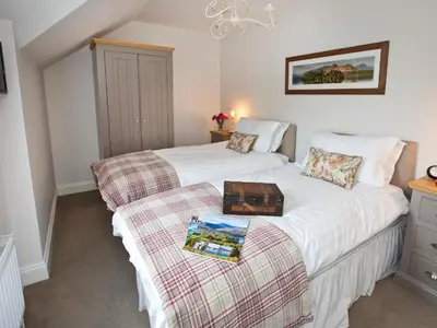 a bedroom with two beds with a tray on the bed at Elmcot in Keswick