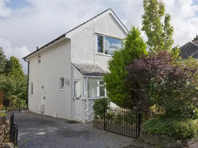 a white house with a fence in front of it at Elmcot in Keswick