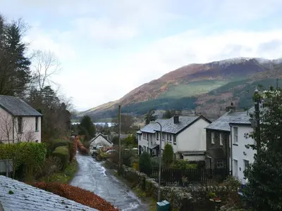 a snow covered street in a village with houses at Fairholme in Braithwaite