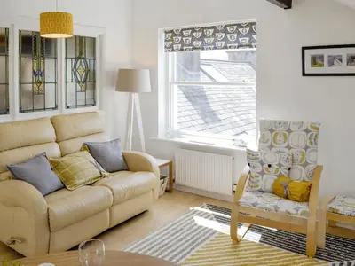 a living room with a couch and a chair at Loft 10 in Keswick