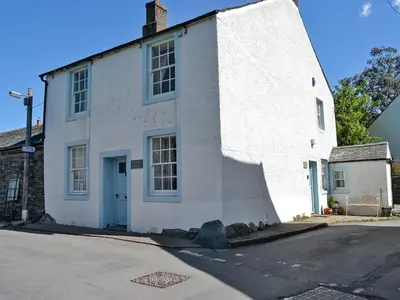 a white building with a blue door on a street at Corner House in Lorton
