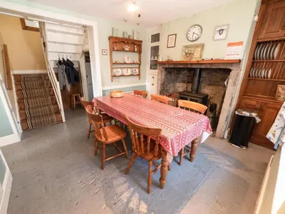 a dining room with a table and chairs and a fireplace at Corner House in Lorton