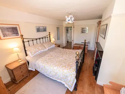 a bedroom with a large bed and a staircase at Corner House in Lorton