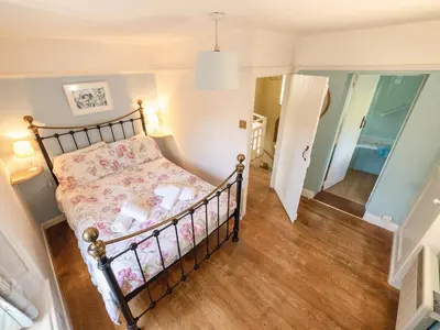 a small bedroom with a bed and a hallway at Corner House in Lorton