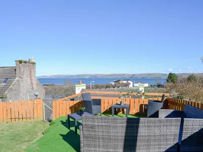 a view of a garden with a fence and a table at Park View Cottage in Stranraer