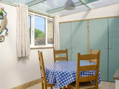 a dining room with a table and chairs at Mill Street in Drummore