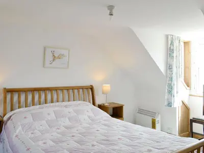 a bedroom with a bed and a window at Mill Street in Drummore