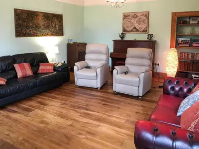 a living room with a couch and two chairs at The Moat House in Annan