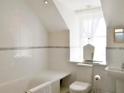 a white bathroom with a toilet and a sink at Fairview in Rockcliffe