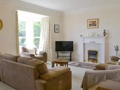 a living room with couches and a television and a fireplace at Fairview in Rockcliffe