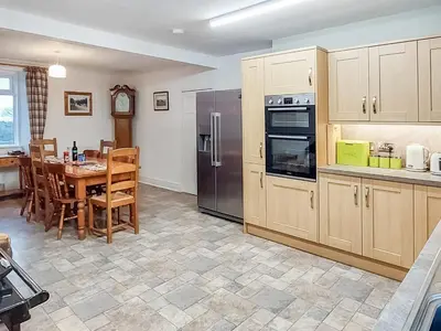 a kitchen with wooden cabinets and a table with a dining room at Culquhasen in Gillespie