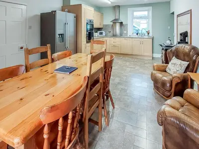 a kitchen and dining room with a wooden table at Culquhasen in Gillespie