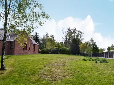 an empty yard in front of a brick house at Perch Hall Cottage in Dinwoodie Mains