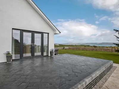 a patio in front of a white house at Quarter Acre House in Challoch