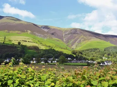 a green hillside with a village in the foreground at Aden Barn in Allonby