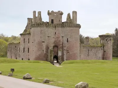 an old castle on a grassy hill with a gate at Hameish Holiday Cottage in Kirkcudbright