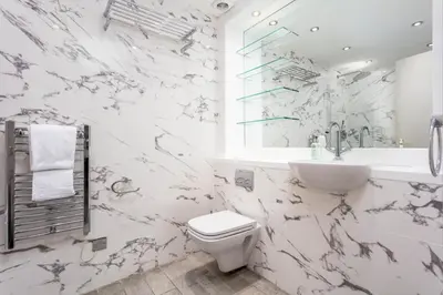 a white bathroom with a toilet and a sink at The Kylestrome in Ayr