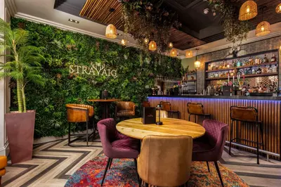 a restaurant with a table and a green wall at The Kylestrome in Ayr